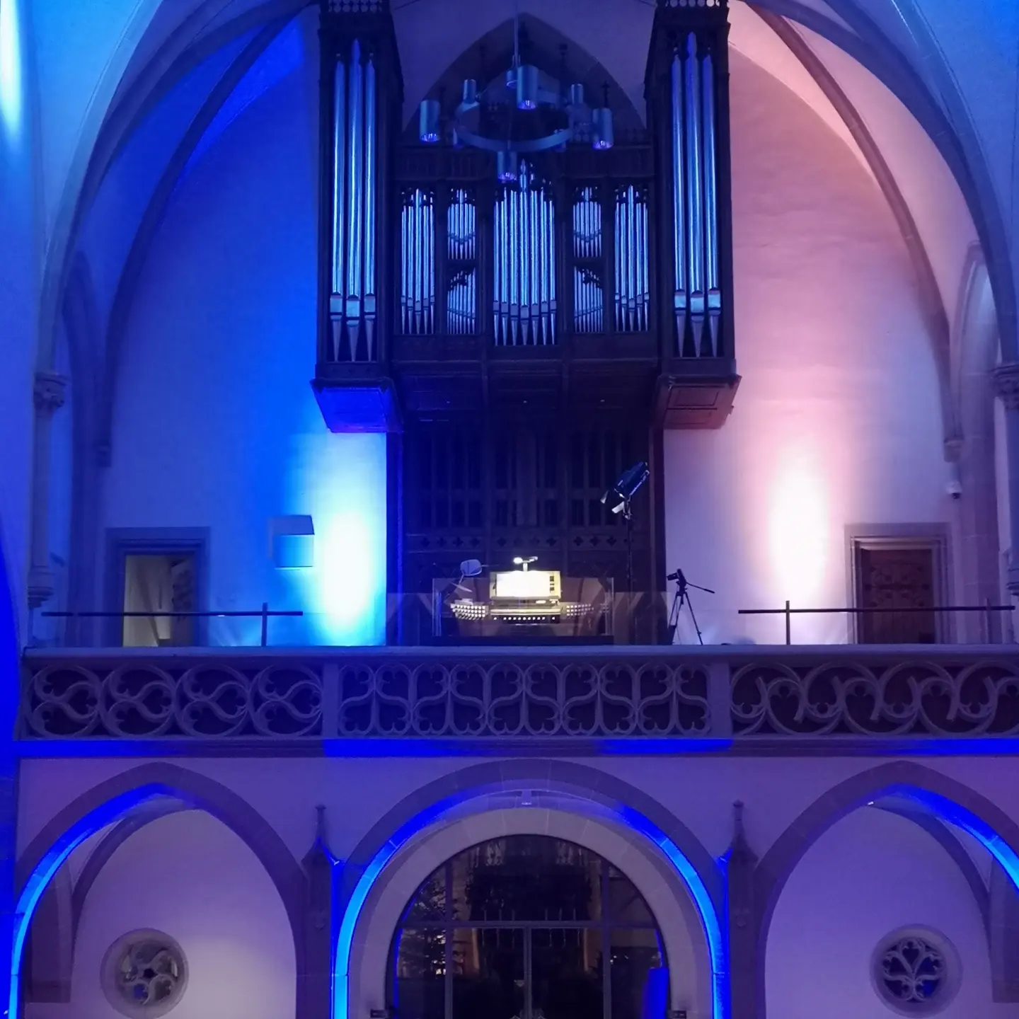 Blick von unten auf die Orgel in St. Ludger Selm, die in blaues Licht getaucht ist